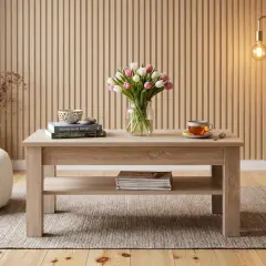 Jasny stolik kawowy 110x60 z tulipanami, książkami i filiżanką herbaty. W tle panel ścienny i lampa.