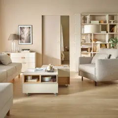 Jasny salon z sofą, fotelem i stolikiem kawowym. Inspiracja, jak ustawić meble w salonie, by stworzyć przytulną przestrzeń.