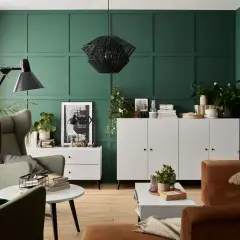 Zieleń ścian pięknie komponuje się z brązową sofą i zielonymi fotelami. Wnętrze z elementami boho i nowoczesnymi.