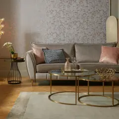 Przytulny salon glamour z beżową sofą, różowymi poduszkami i złotymi dodatkami.