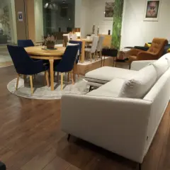 Nowoczesna aranżacja salonu z szarą kanapą i granatowymi krzesłami przy okrągłym stole. Czy krzesła muszą być w kolorze kanapy?