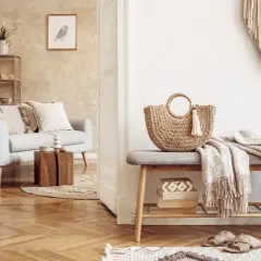 Przytulny salon w stylu boho. Jasna kanapa, pleciona torba i makrama tworzą relaksującą atmosferę.