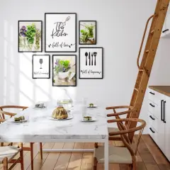 Pusta ściana w kuchni ozdobiona ramkami z motywami roślinnymi i kuchennymi. "This kitchen full of love" - napis na jednej z nich.