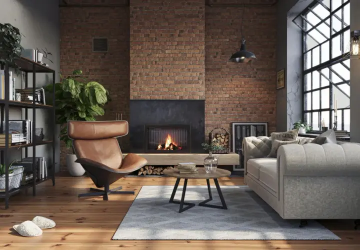 Przytulny salon w stylu soft loft z ceglaną ścianą, kominkiem, wygodnym fotelem i sofą.