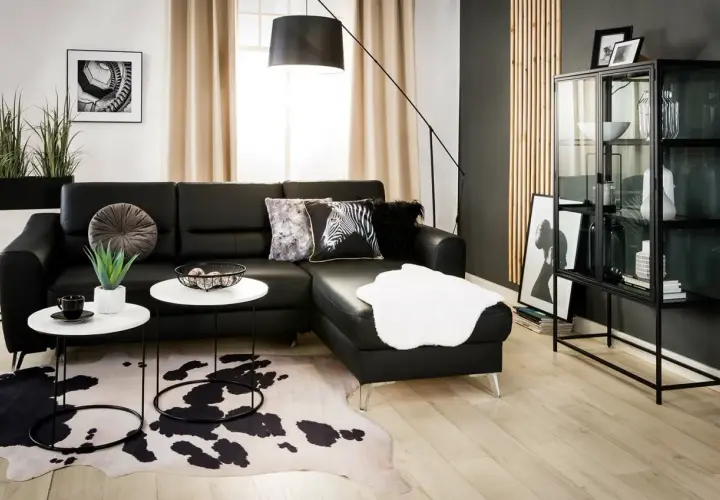 Nowoczesny salon z czarną sofą, dywanem w cętki i czarną ścianą inspiracje.