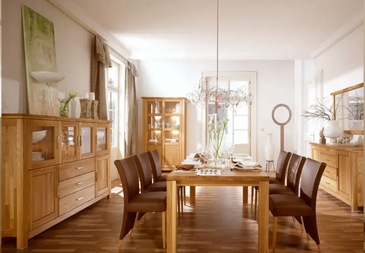 Nowoczesny salon ze starymi meblami z litego drewna. Dębowe komody i witryny tworzą ciepłą atmosferę, a skórzane krzesła dodają elegancji.