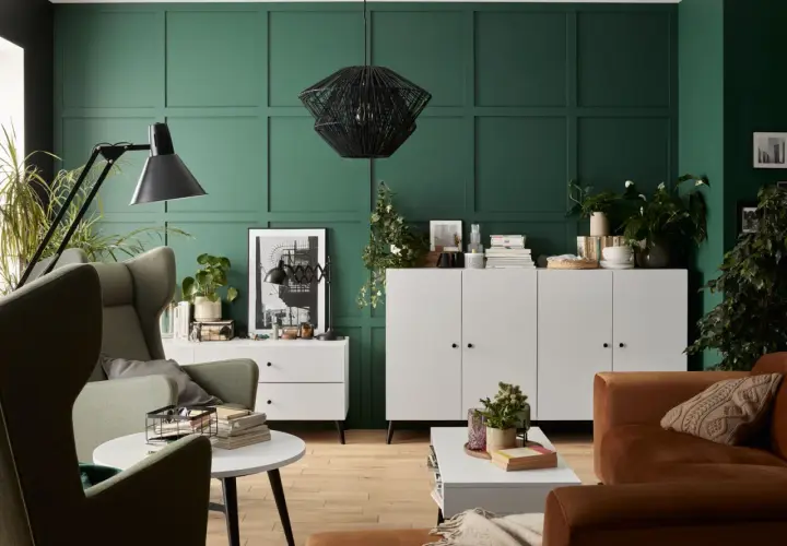 Zieleń ścian pięknie komponuje się z brązową sofą i zielonymi fotelami. Wnętrze z elementami boho i nowoczesnymi.