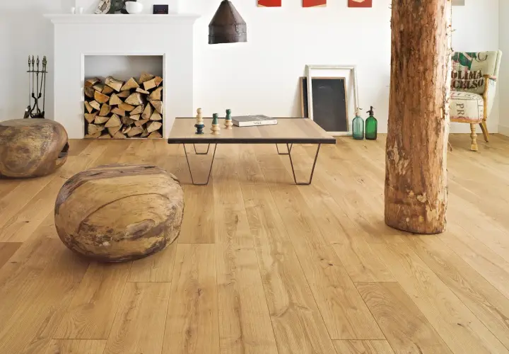 Salon w stylu francuskim inspiracje: drewniane pnie, kominek z polanami, stolik kawowy i fotel z worka.