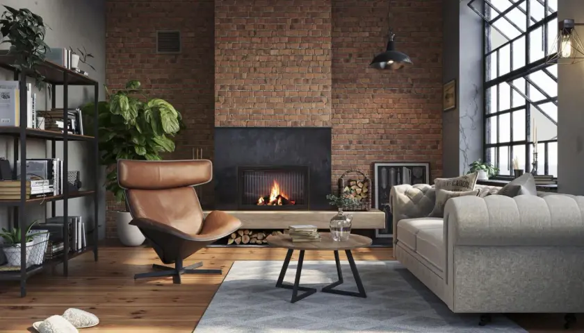 Przytulny salon w stylu soft loft z ceglaną ścianą, kominkiem, wygodnym fotelem i sofą.