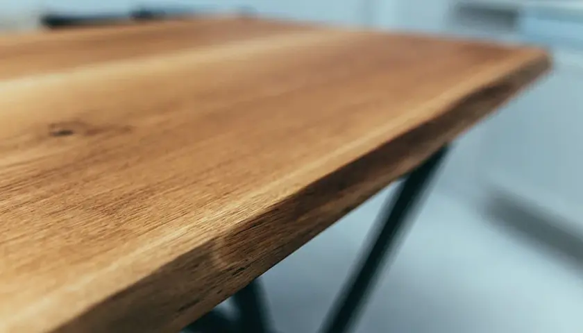 Piękny, dębowy blat stołu z widocznym usłojeniem. Zastanawiasz się, czym wyczyścić drewno, by zachować jego naturalne piękno?