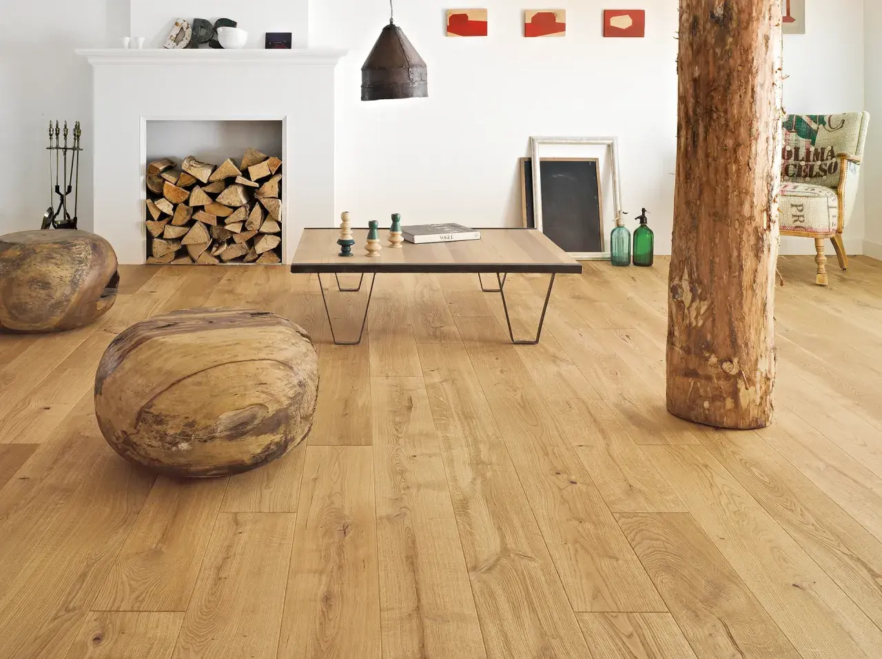 Salon w stylu francuskim inspiracje: drewniane pnie, kominek z polanami, stolik kawowy i fotel z worka.
